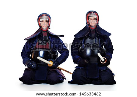 Two kendo fighters posing together over white background. Asian martial arts.