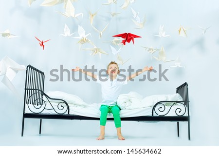 Cute Little Boy Sitting On His Bed Surrounded By Paper Birds. Dream World.