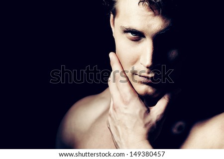 Portrait of a handsome muscular young man. Black background.