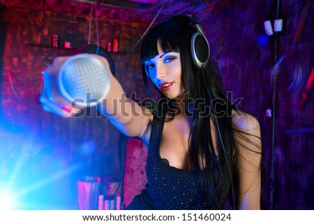 Beautiful sexy girl singing on a party in the old garage.