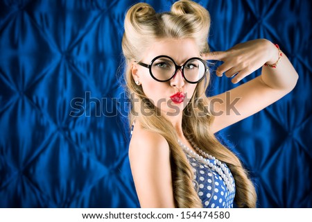 Charming pin-up woman with retro hairstyle and make-up reading a book.