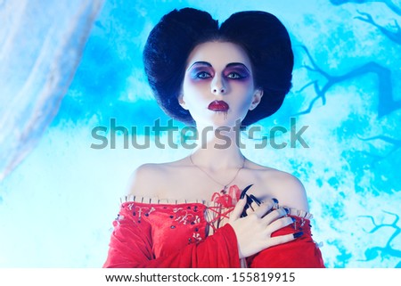 Portrait of a beautiful female vampire over moonlight background.