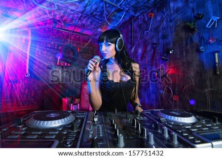 Beautiful sexual DJ girl working on a party in the old garage.
