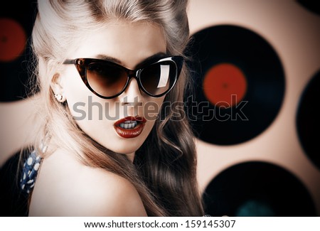 Portrait Of A Charming Pin-Up Woman With Retro Hairstyle And Make-Up Posing With Vinyl Record.