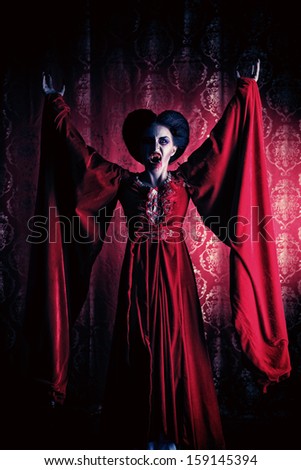 Portrait of a bloodthirsty female vampire over red vintage background.