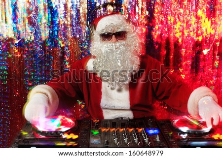 DJ Santa Claus mixing up some Christmas cheer. Disco lights in the background.