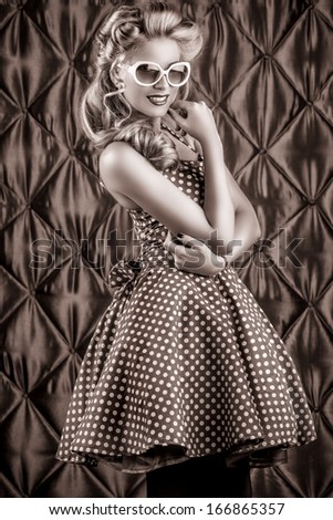 Black-and-white portrait of a charming pin-up woman with retro hairstyle and make-up.