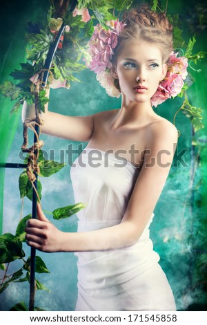 Beautiful Young Woman Standing Under An Arch Of Flowers And Overgrown Loach. Magic Of The Spring.