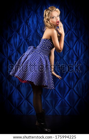 Full length portrait of a charming pin-up woman with retro hairstyle and make-up.