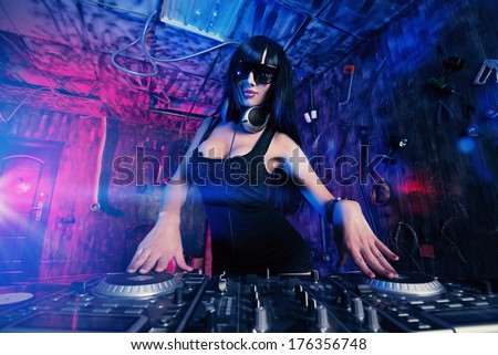 Beautiful sexual DJ girl working on a party in the old garage.