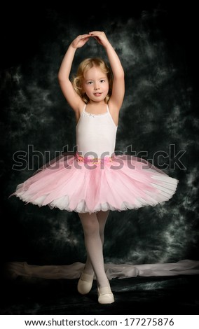 Pretty little girl ballerina in tutu posing over vintage background Pretty little girl ballerina in tutu posing over vintage background
