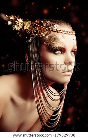 Art project: beautiful woman with golden make-up. Jewelry, make-up. Fashion.