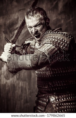 Portrait of a courageous ancient warrior in armor with sword.