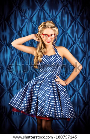 Gorgeous pin-up woman with retro hairstyle and make-up wearing red spectacles.