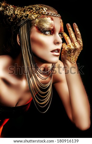 Art project: beautiful woman with golden make-up. Jewelry, make-up. Fashion.