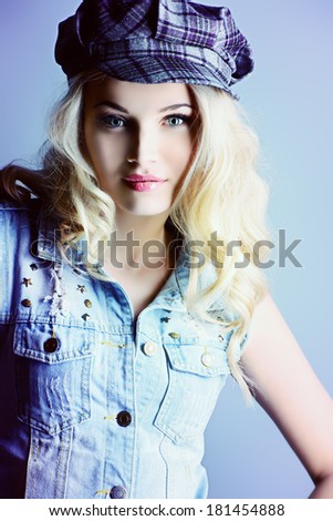 Pretty blonde woman in jeans jacket smiling at camera. Jeans style.