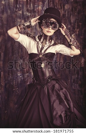 Portrait of a beautiful steampunk woman over grunge background.