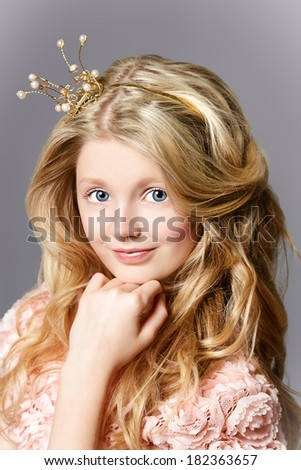 Portrait of a beautiful girl who looks like a little princess with a crown on her head.