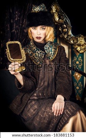 Portrait of a beautiful fashion model in a rich historical costume. Fur clothing. Vintage. Luxury style.