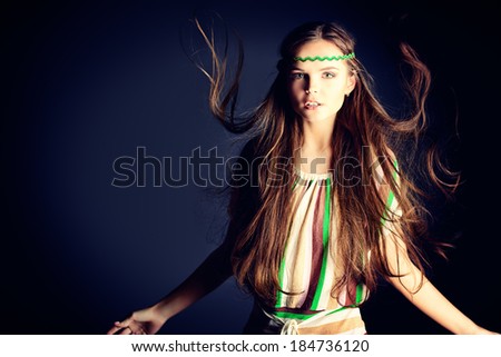 Beautiful girl with natural make-up and long hair in motion. Hippie style.
