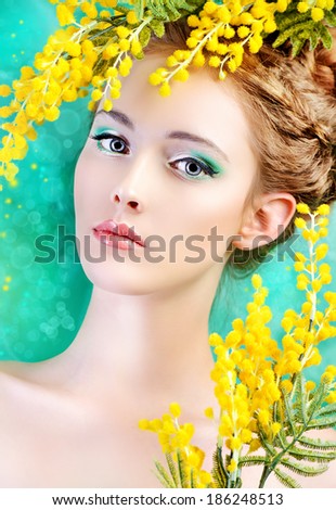 Portrait of a beautiful girl with mimosa flowers. Spring.