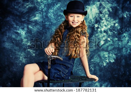 Portrait of an elegant teen girl wearing retro dress and bowler hat.