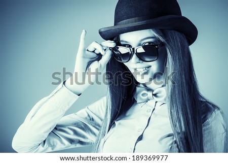 Elegant girl model poses in blouse, bow tie and bowler hat. Refined style of old Europe.