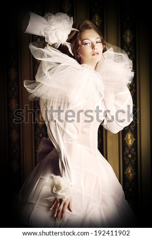 Beautiful fashion model in the refined white dress and elegant hat. Vintage style. Art project.