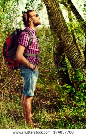 Young man hiking in the forest, countryside. Active lifestyle, tourism.