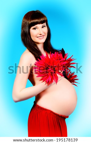 Portrait of a beautiful pregnant woman with flowers. Pregnancy. Healthcare. Studio shot.