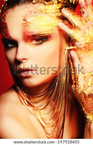 Art project: beautiful woman with golden make-up. Jewelry, make-up. Fashion. Light effects.