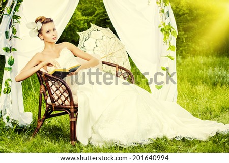Charming elegant bride under the wedding arch. Wedding dress and accessories. Wedding decoration.