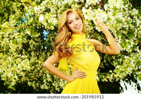 Romantic young woman in the spring garden among apple blossom.