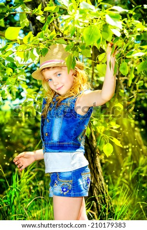 Funny little girl in the countryside. Happy childhood. Western style, jeans.