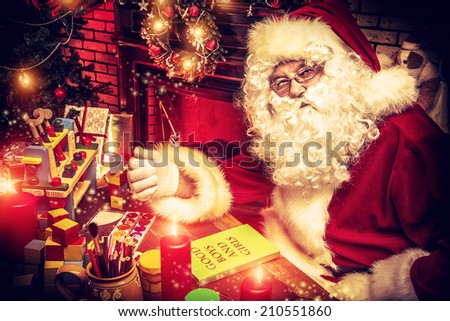 Santa Claus making Christmas gifts at home.