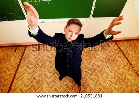 Smart schoolboy stands at the blackboard in the classroom. Education.