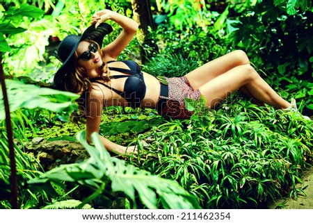 Beautiful young woman  among the tropical plants. Vacation. Tropics. Fashion shot.