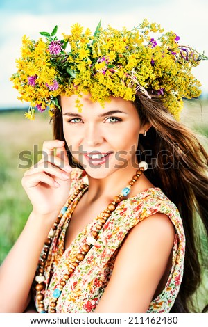 Romantic girl in a wreath of wild flowers in a field. Summer life. Beauty.