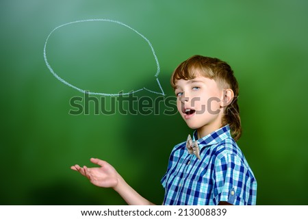 Smart schoolboy stands at the blackboard in the classroom. Education. New idea.