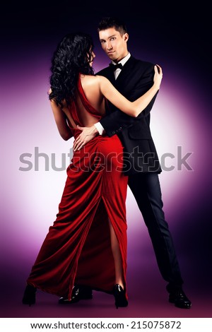 Beautiful young couple in love dancing passionate dance. Studio shot.