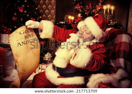 Santa Claus sitting in a room decorated for Christmas, and carefully read the list of good boys and girls. Christmastime.
