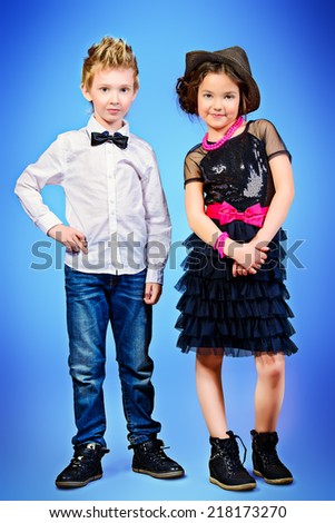 Full length portrait of two modern kids posing together. Fashion shot.
