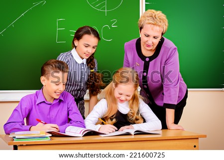 A teacher and her students during class at school. Education.