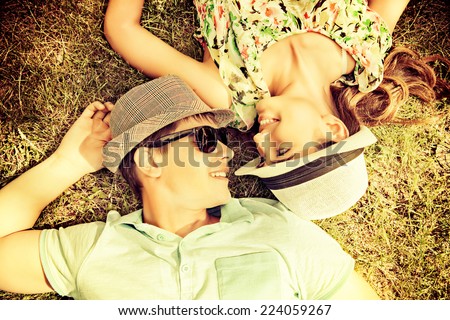 Happy young couple relaxing on the lawn in a summer park. Love concept. Vacation.
