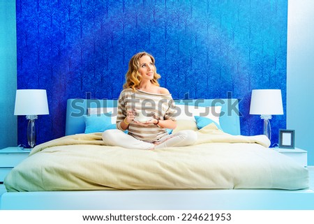 Happy elegant woman having a rest in her bedroom. Home interior, furniture. Lifestyle.