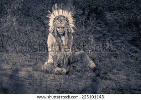 Fashion shot of a beautiful girl in style of the American Indians. Western style. Jeans fashion. Toned photo.
