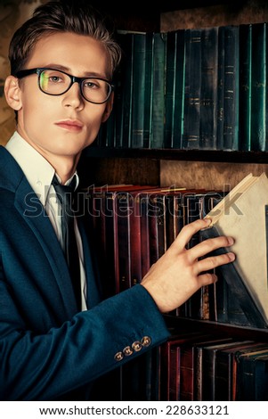 Close-up portrait of a respectable handsome man in his cabinet, library. Classic vintage style.