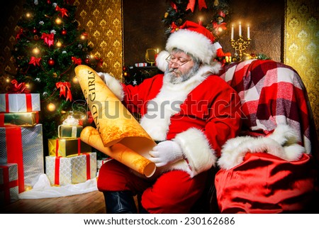 Santa Claus sitting in a room decorated for Christmas, and carefully read the list of good boys and girls. Christmastime.