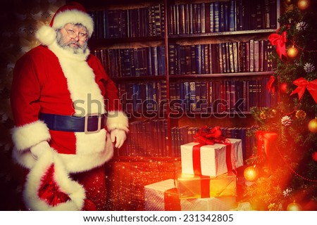 Tired Santa Claus stands by the fireplace with a bag of gifts. Christmas home decoration.