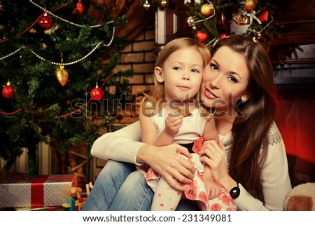 Mother and daughter on the background of the Christmas tree